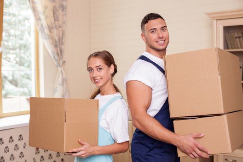 Moving team carrying furniture through a Balham property entrance